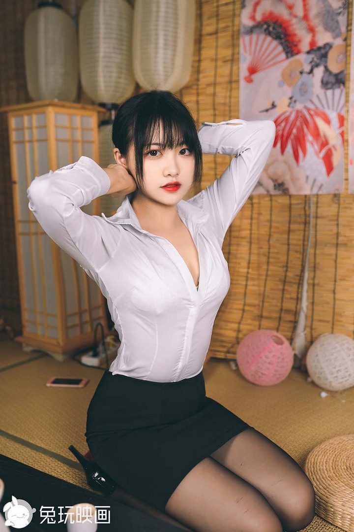 一位模特扮演日系OL女神，身穿白色紧身衬衫和黑色短裙，身处于一间充满日式风格的榻榻米房间里。