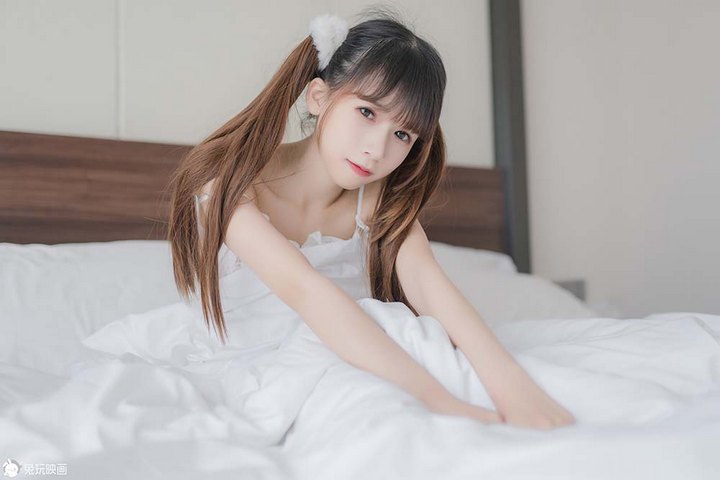 一位扎着双马尾的软萌少女，身穿白色蕾丝吊带和南瓜短裤，在明亮的窗户旁边，姿态娇羞。